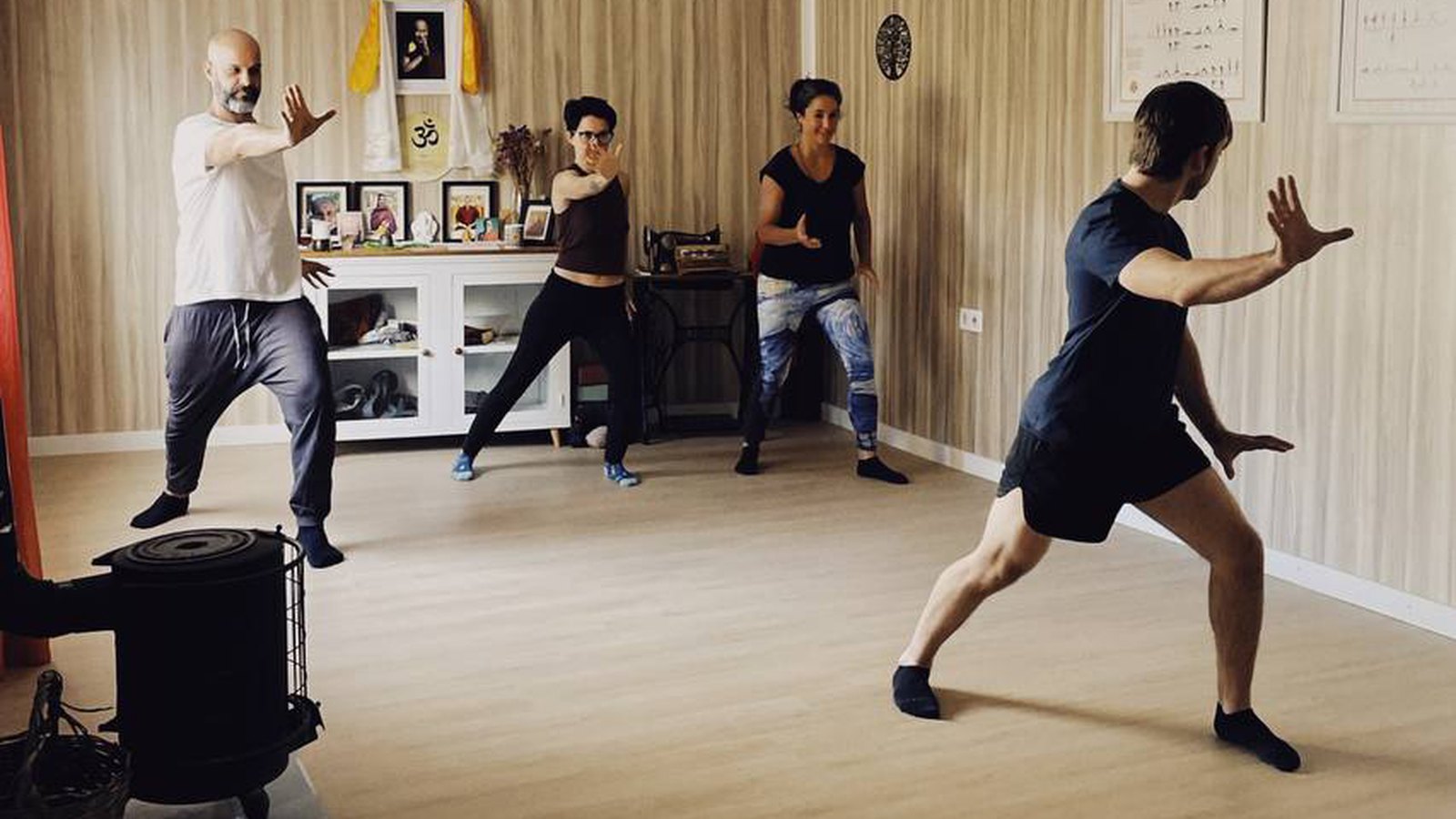 Clase de Tai Chi en la sala de Espacio Amarillo, cuatro personas en posición